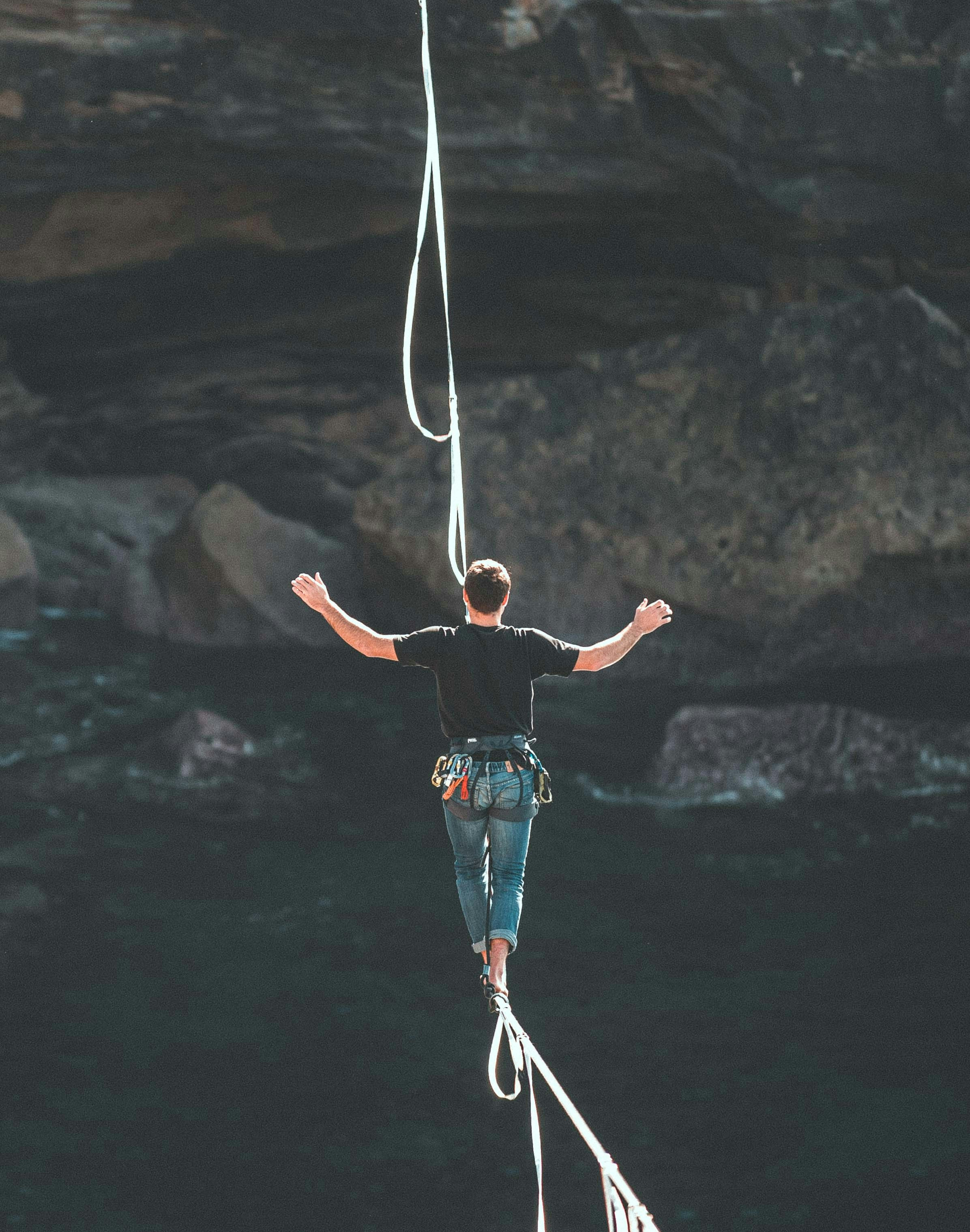 A man managing risk walking a tightrope